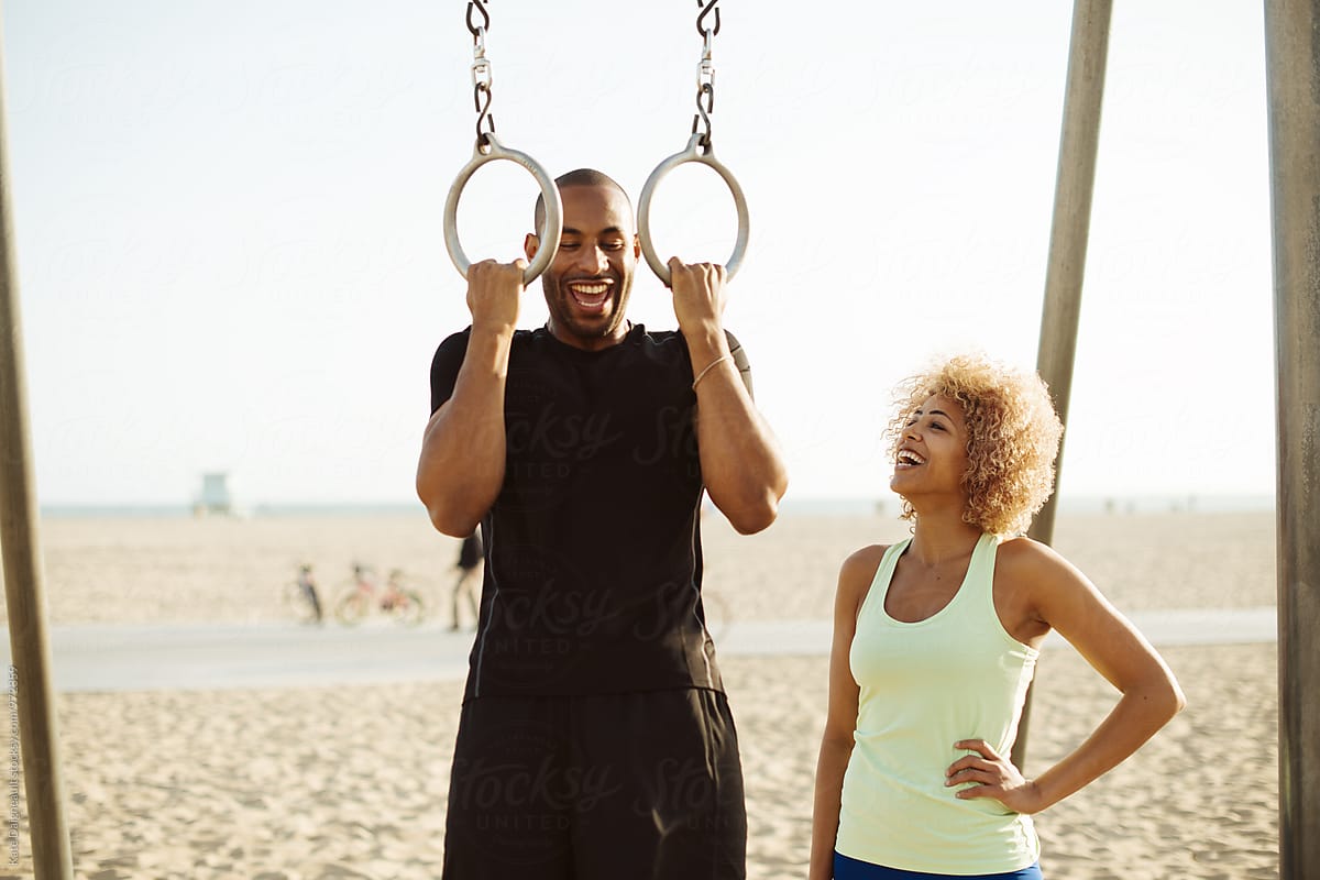 Cute African American couple workout together by the beach.