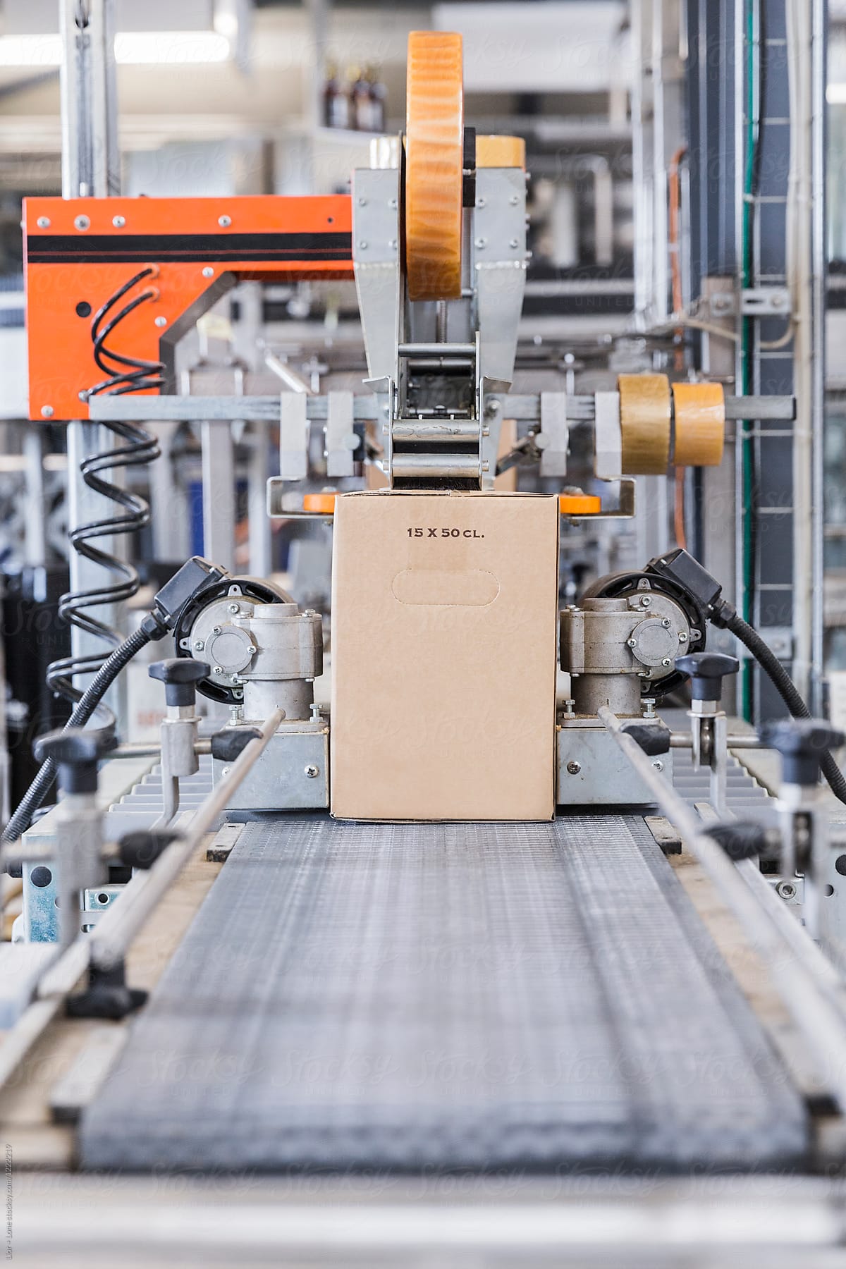 Cardboard box being sealed by machine in a factory