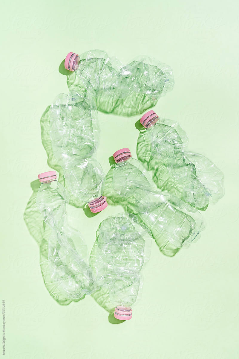 Plastic problem. Empty bottles on green background.