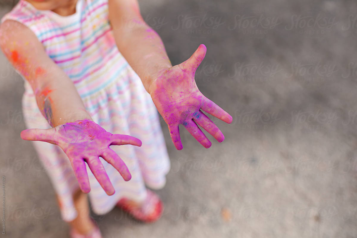 Crop little girl showing hands with gulal powder