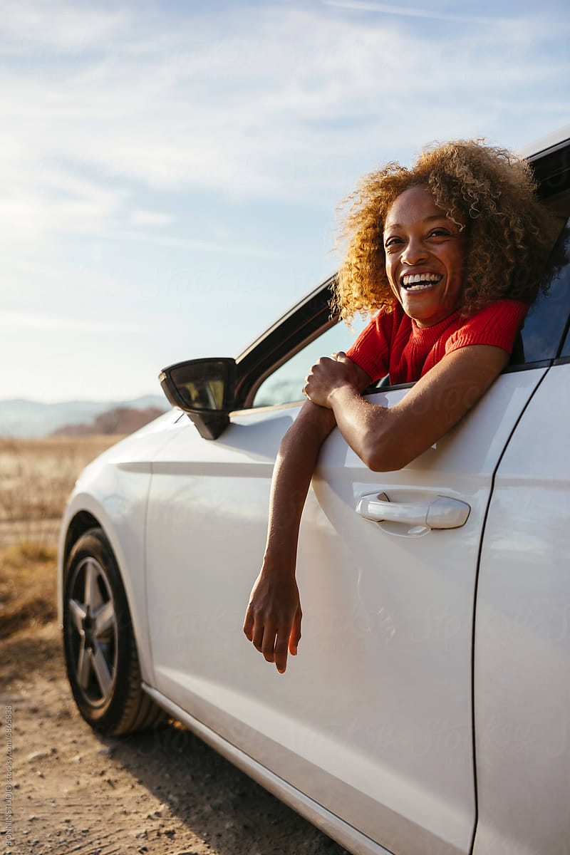 Smiling woman leaning on car