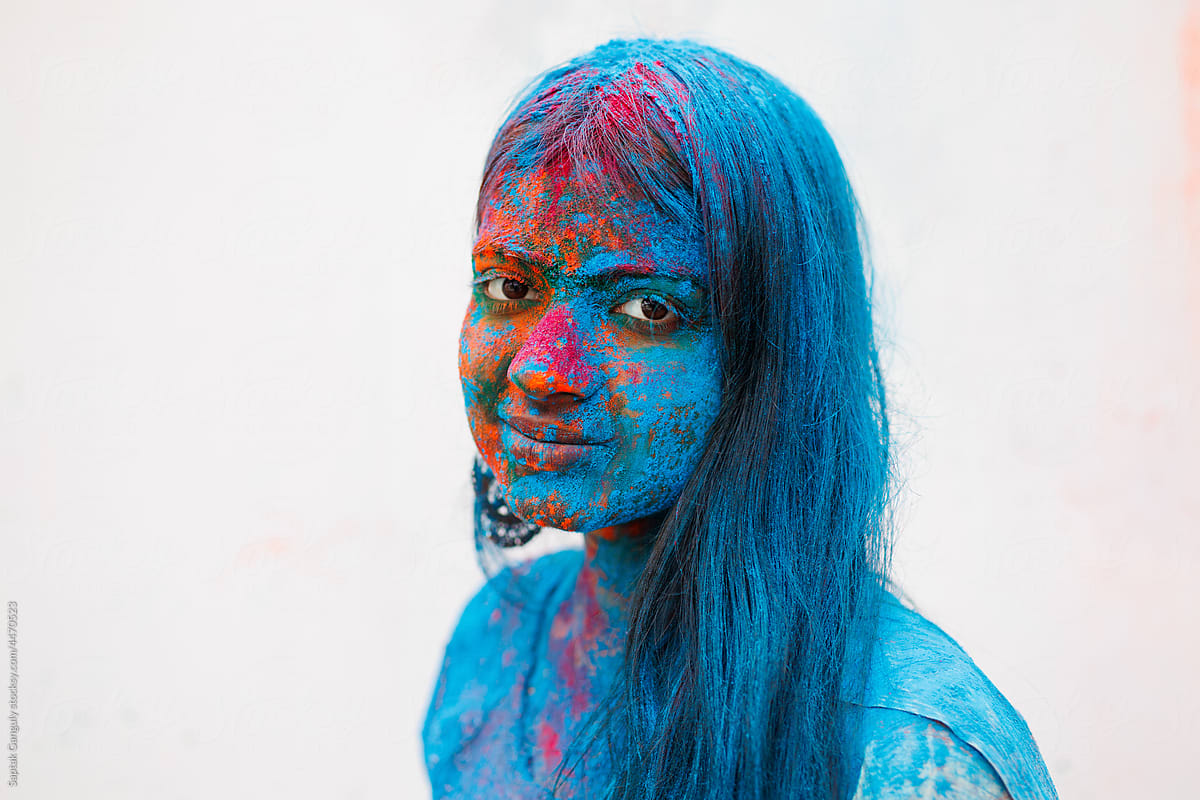 Portrait of young woman smeared with color powders