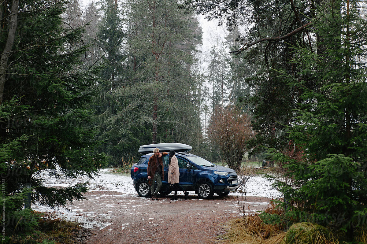Couple in woods with blue car