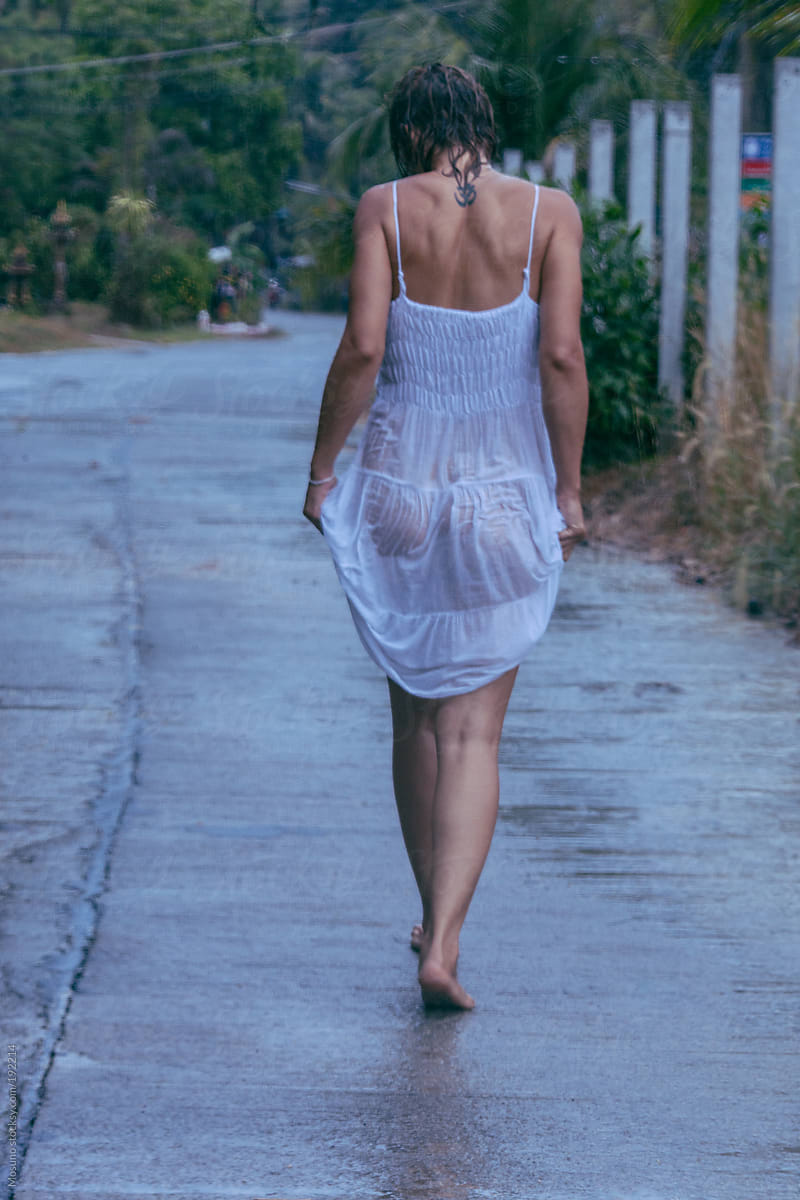 Woman Walking in a Wet Dress After the Rain by Mosuno for Stocksy United.
