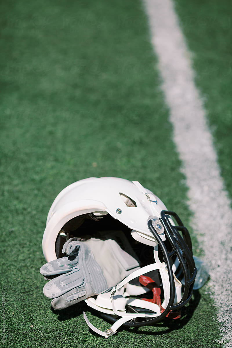 American footbal concept with white crash helmet on the grass