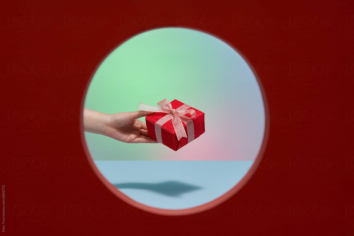 A Person Holding Present Box with Red Ribbon.