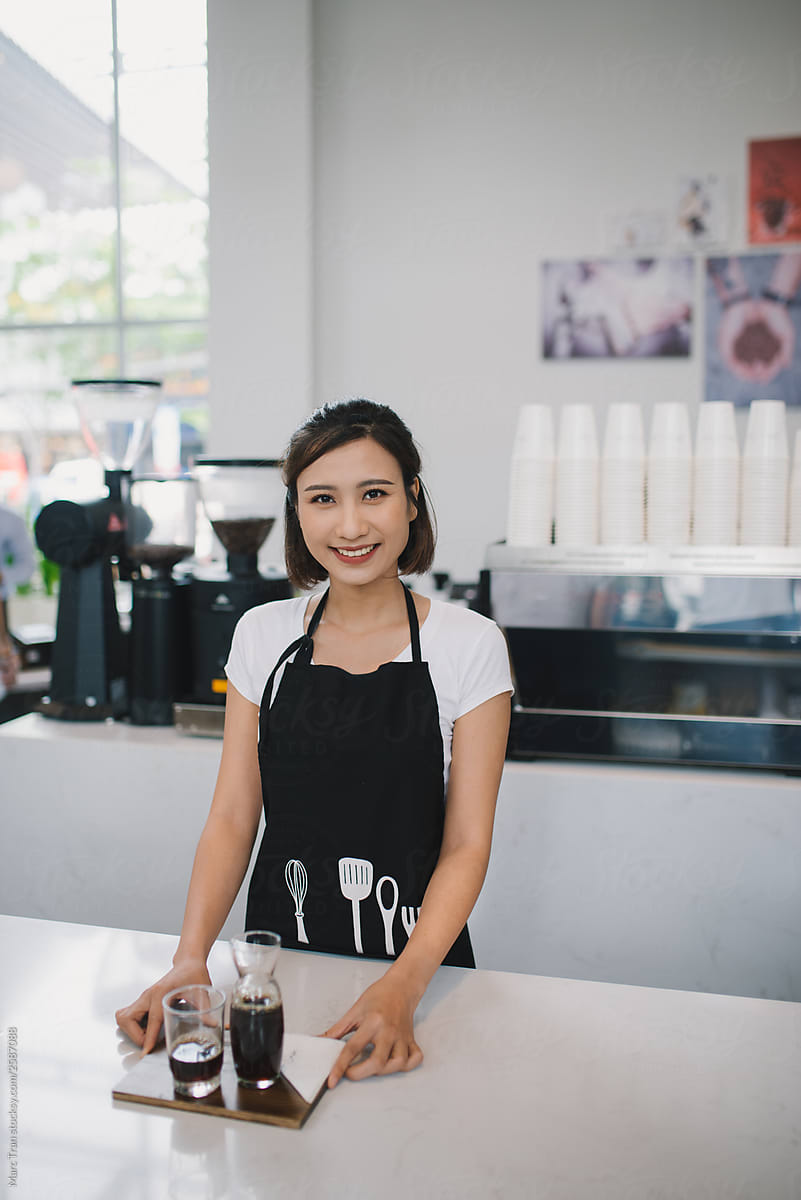 Happy barista woman with espresso at coffee shop