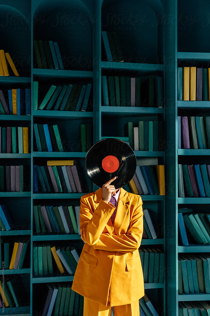 Unrecognizable woman hiding face with gramophone record
