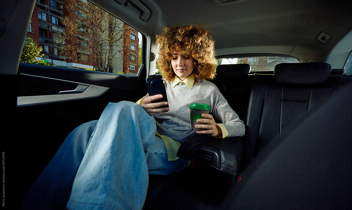 Curly woman rides in a car