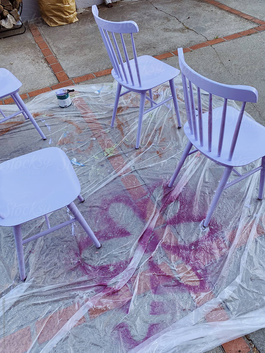 Spray painted flower outline on paint cloth with four chairs