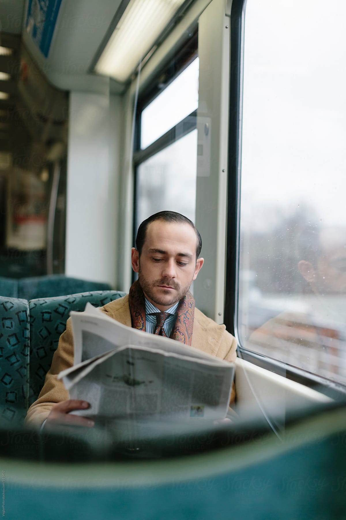 Businessman Reading Newspaper In Commuter Train