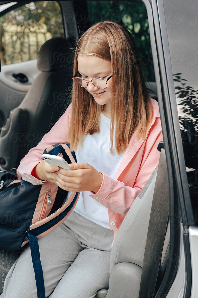 Happy Teen Girl Engaged with Phone Apps on the Way to School