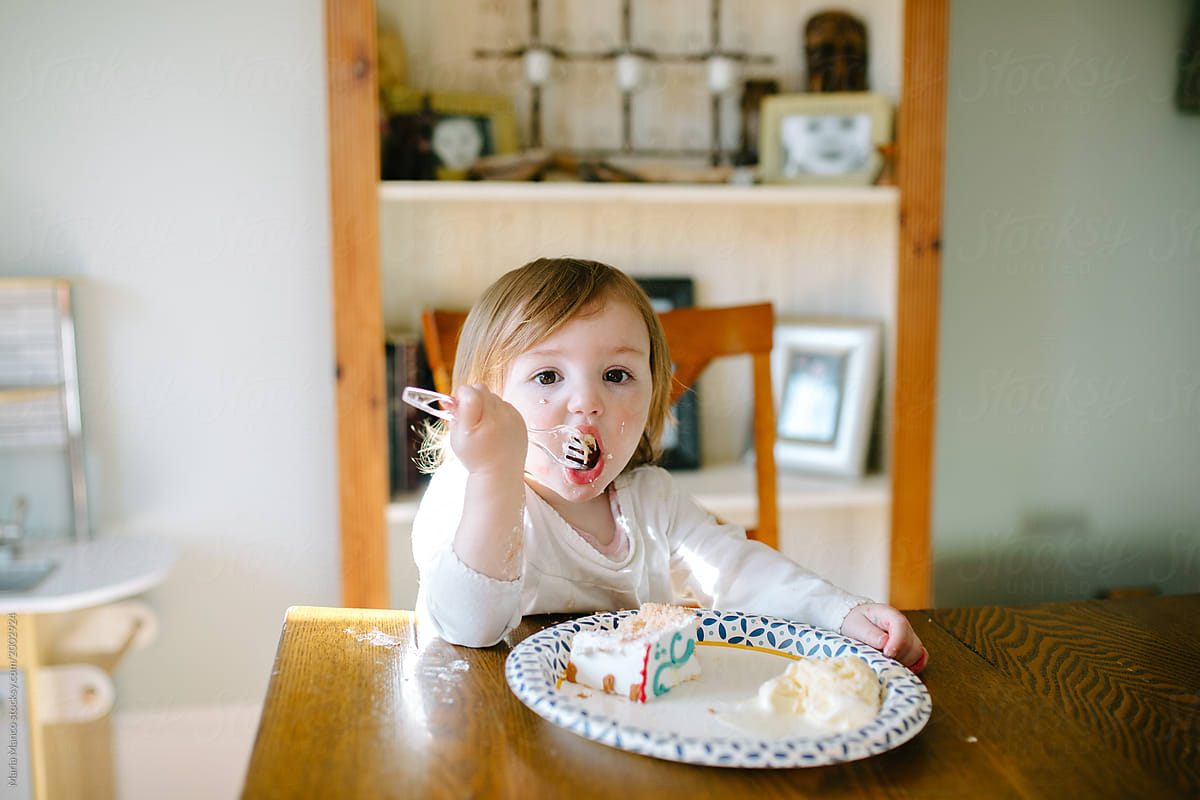 toddler eating cake and making a mess