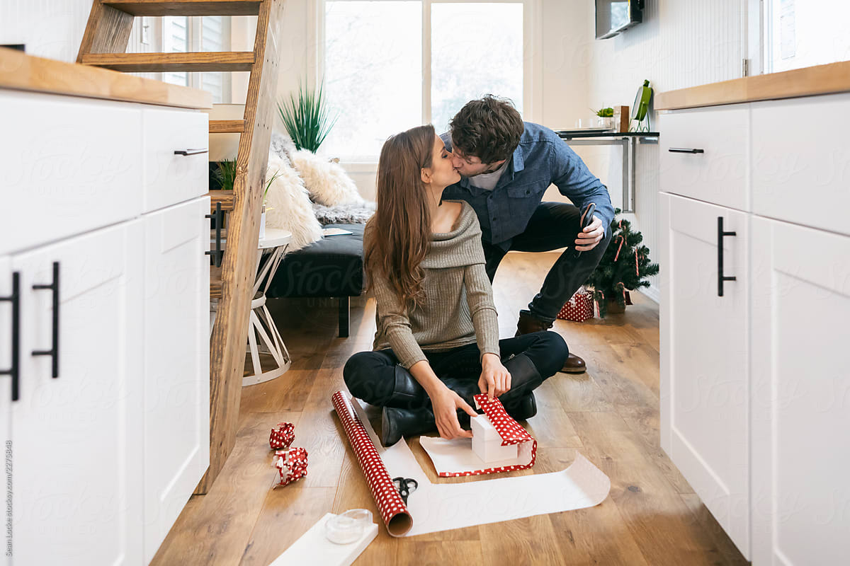 Home: Couple Kisses While Wrapping Gifts In Tiny House