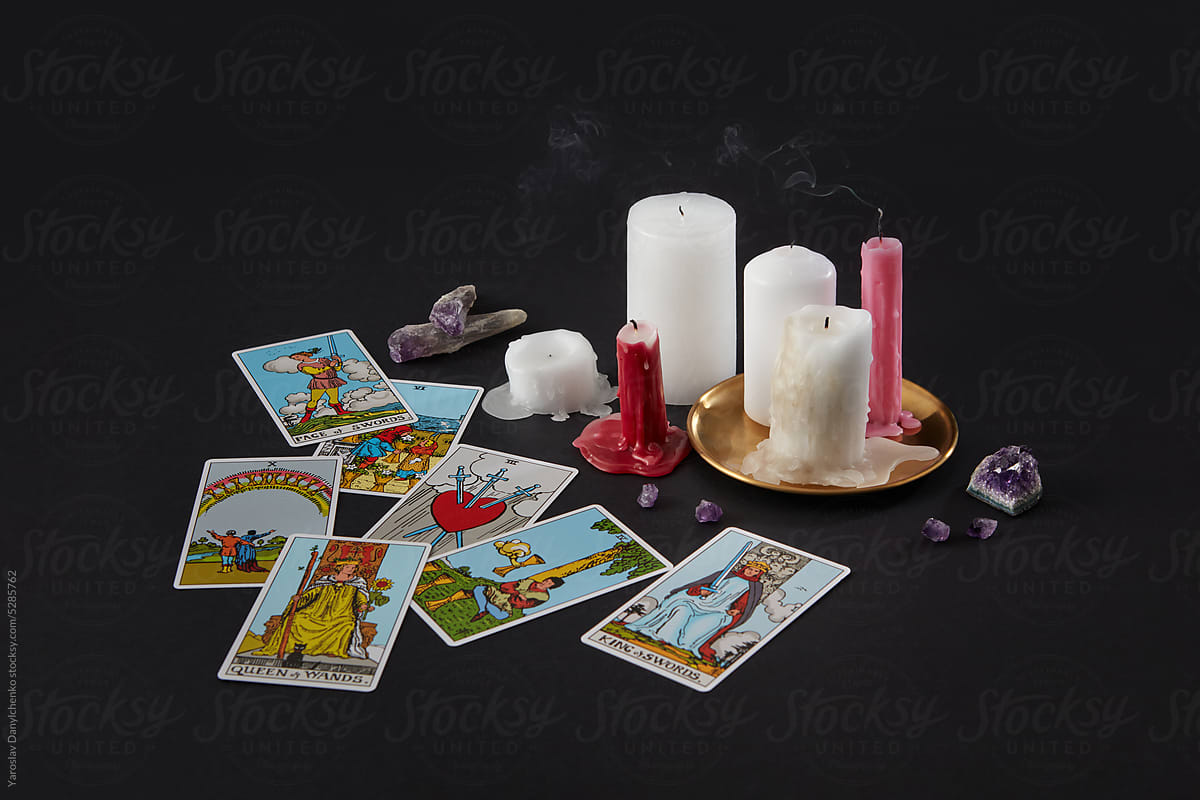 Tarot cards layout with extinguished candles and crystals.