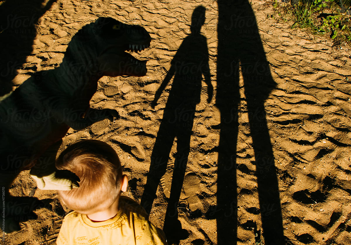 The shadows of the child and mother on the sand.