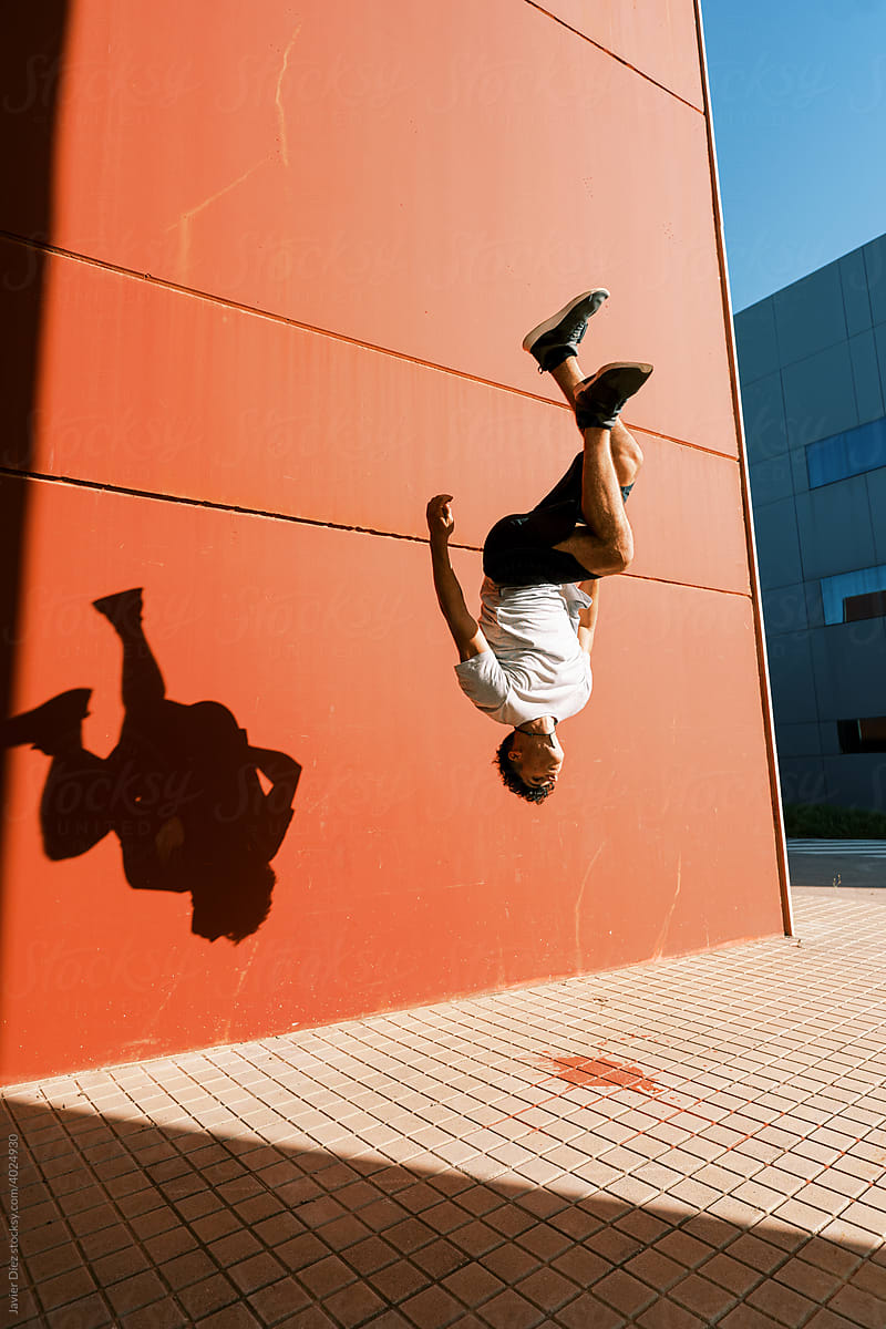 Energetic man performing trick near wall