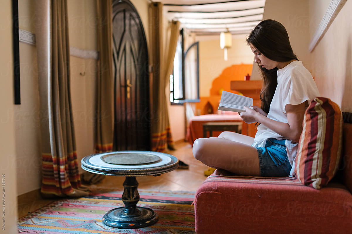 Woman reading book in Moroccan apartment