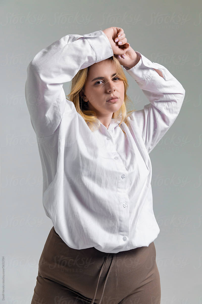 Young plus size woman standing with hands over head