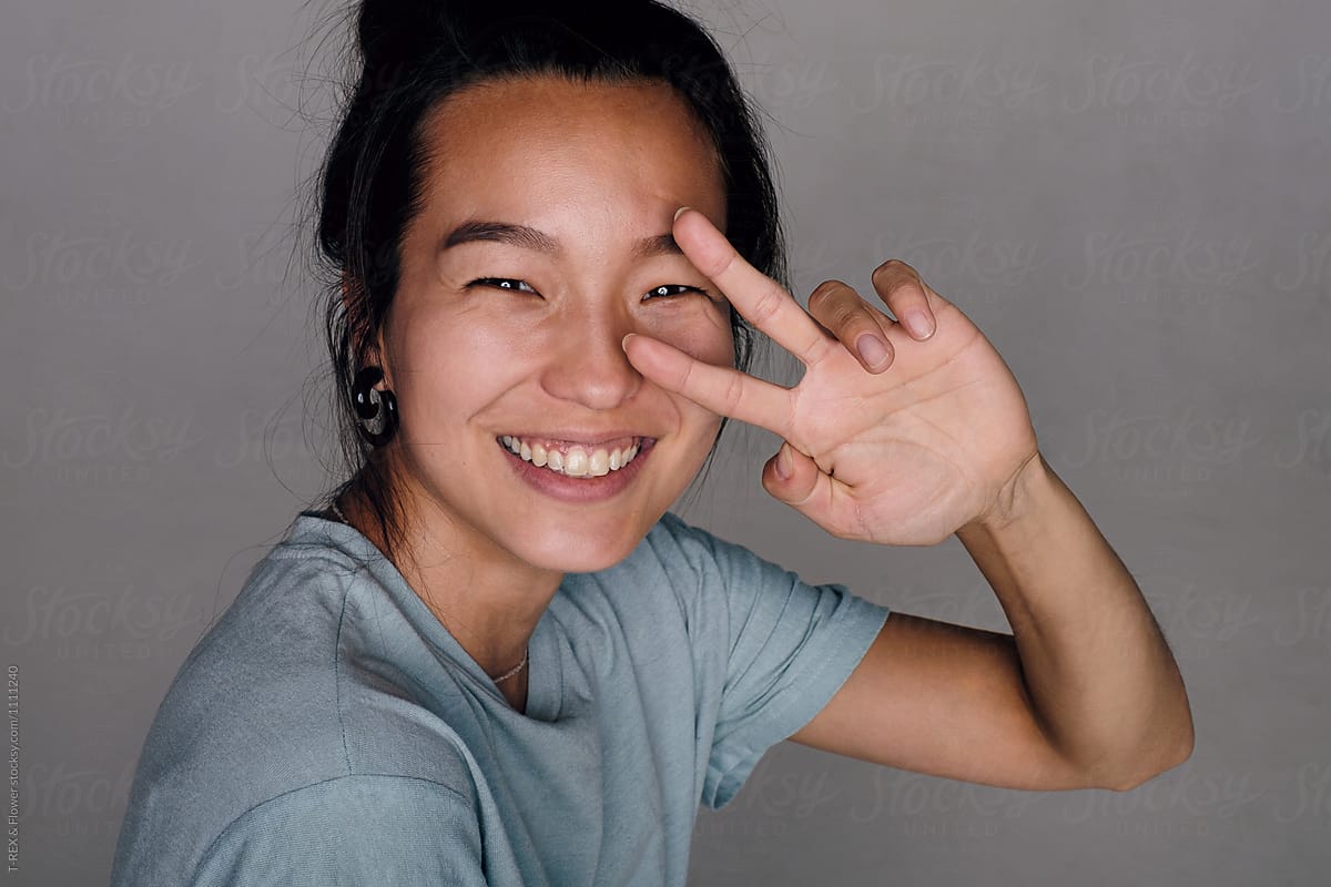 Smiling Asian girl showing peace sign