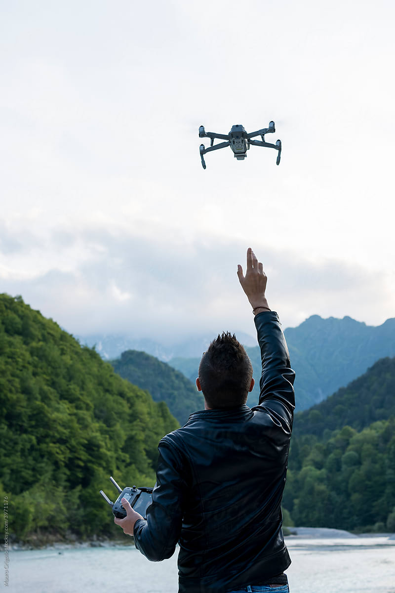 Man flying a drone at the lake on mountains