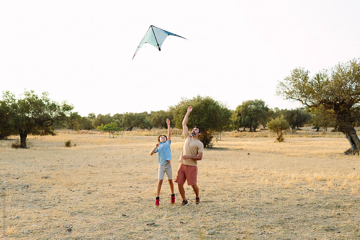 Father and son making fly a kite