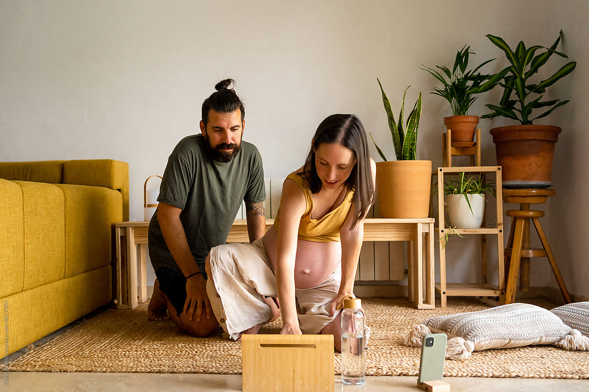 Couple doing a yoga class at home using the tablet