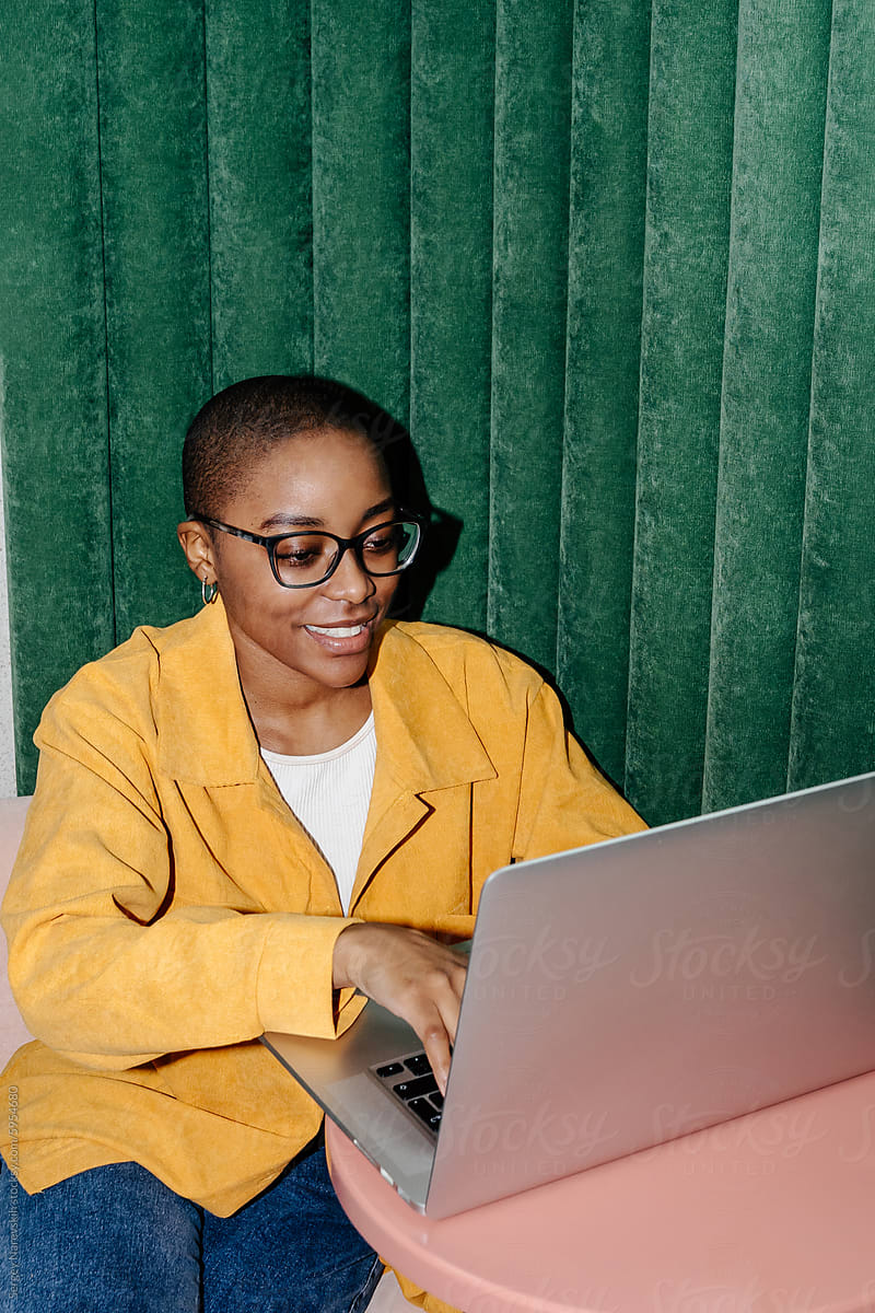 Focused female freelancer using laptop in coworking space