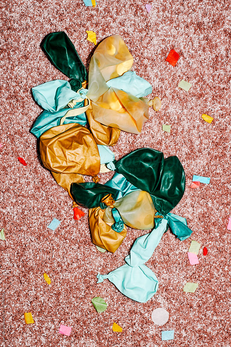 deflated balloons and confetti on the carpet