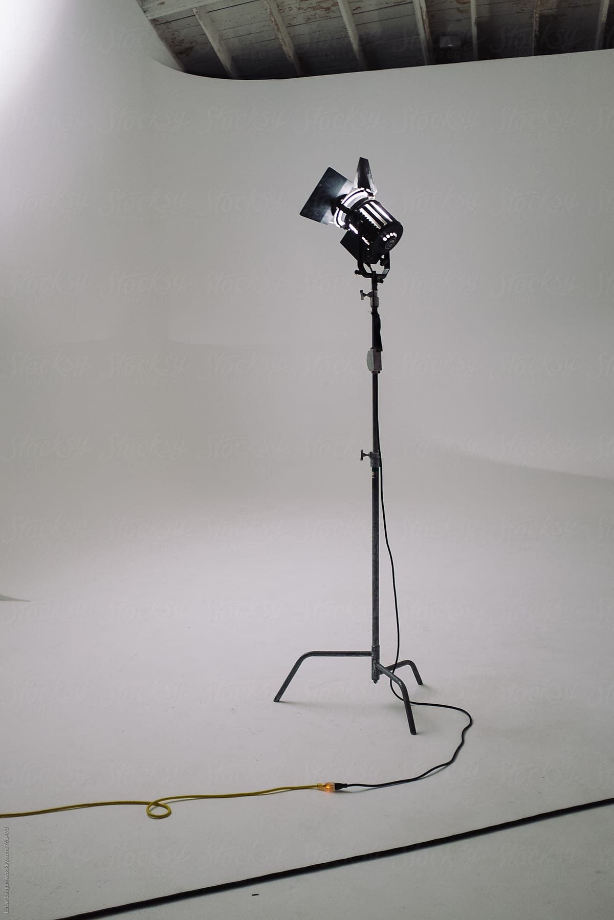 A lone light on a stand in a white studio.