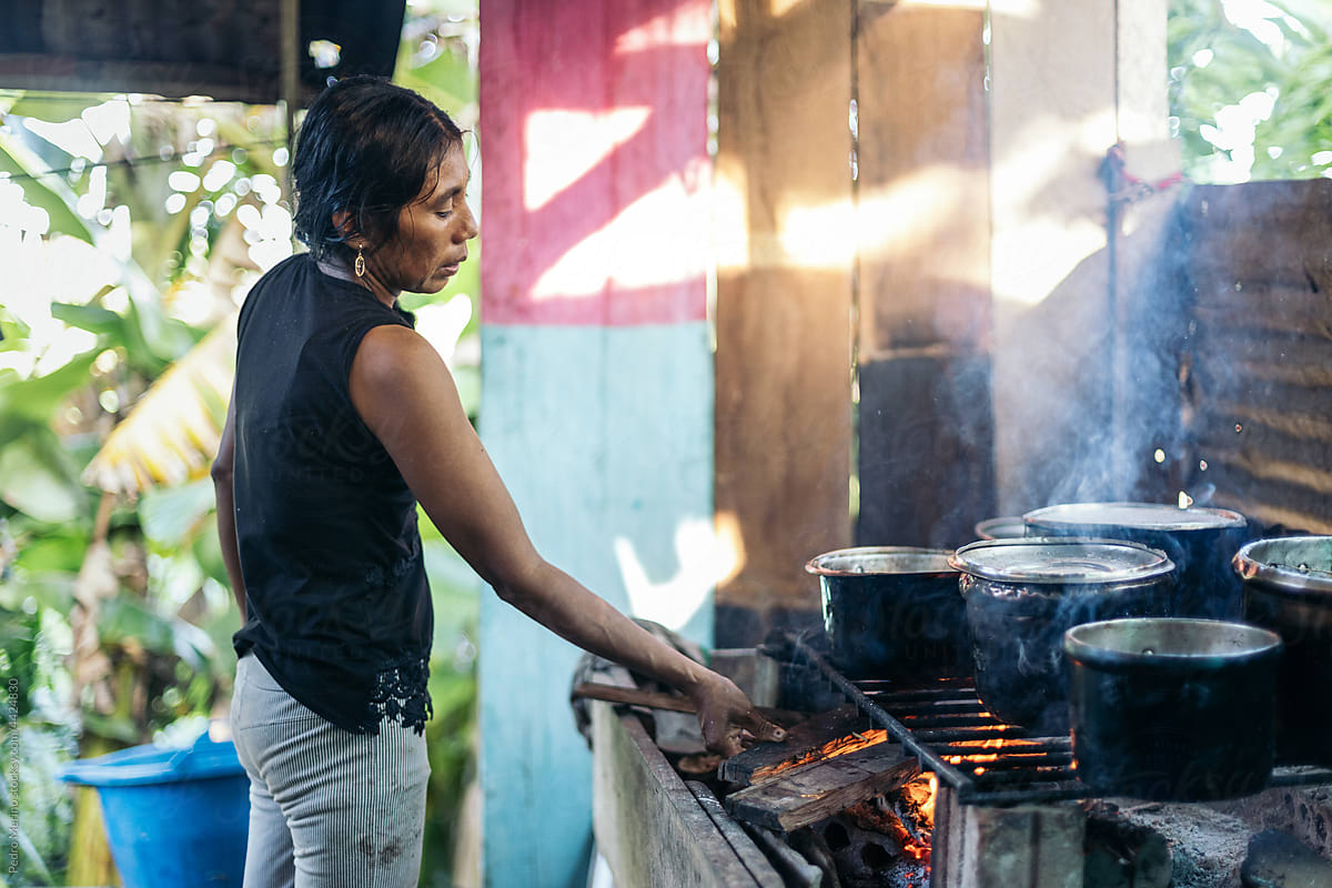 Peruvian woman preparing the wood fire for cooking