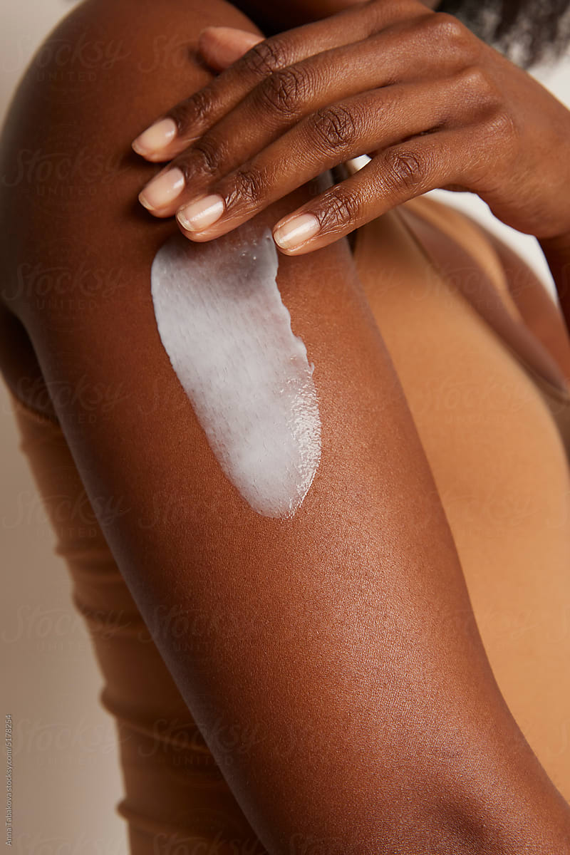 Woman applying cream on her arm