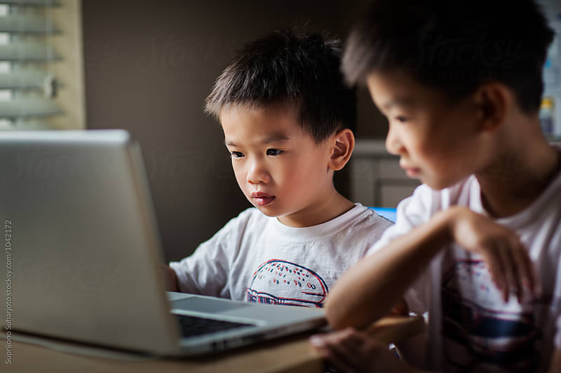 Asian kids using a laptop at home