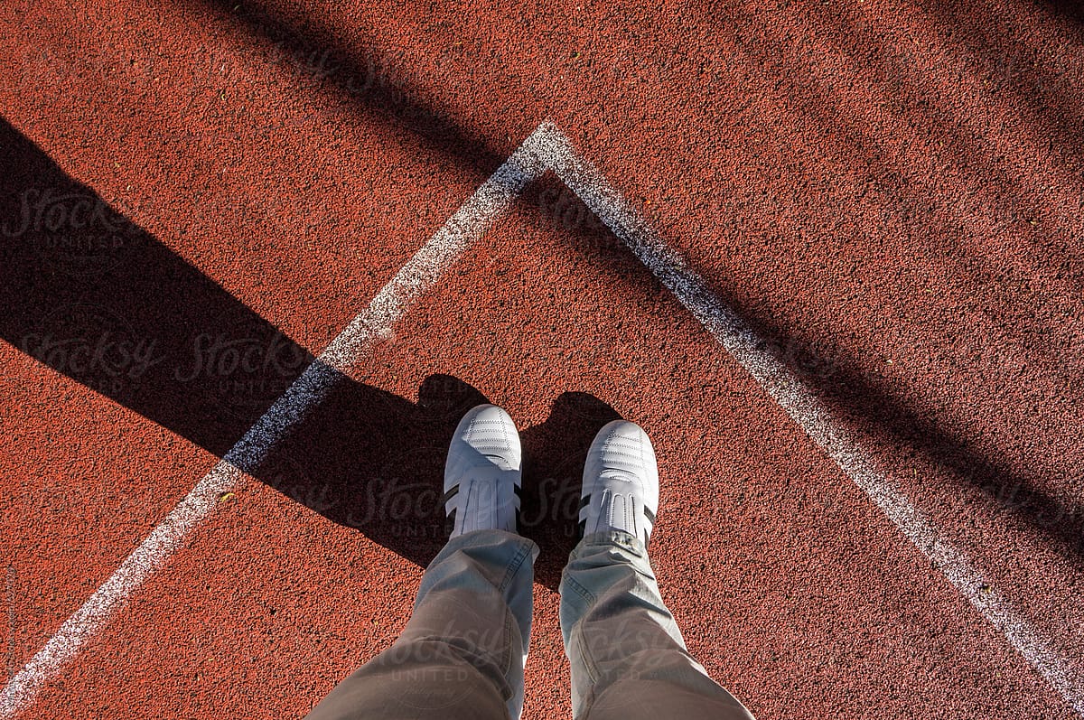 White sneakers in corner of sport field, footsie, personal perspective
