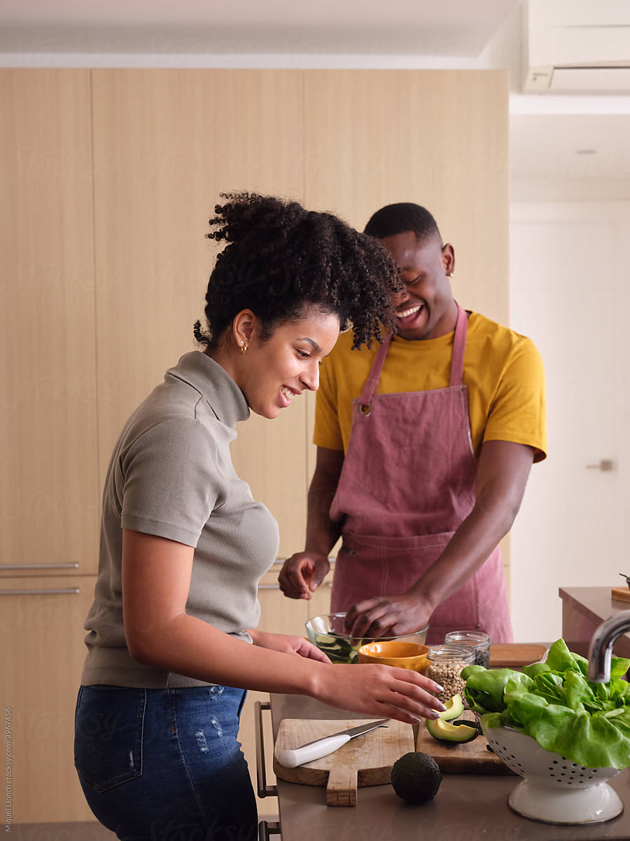Happy Black couple cooking together.