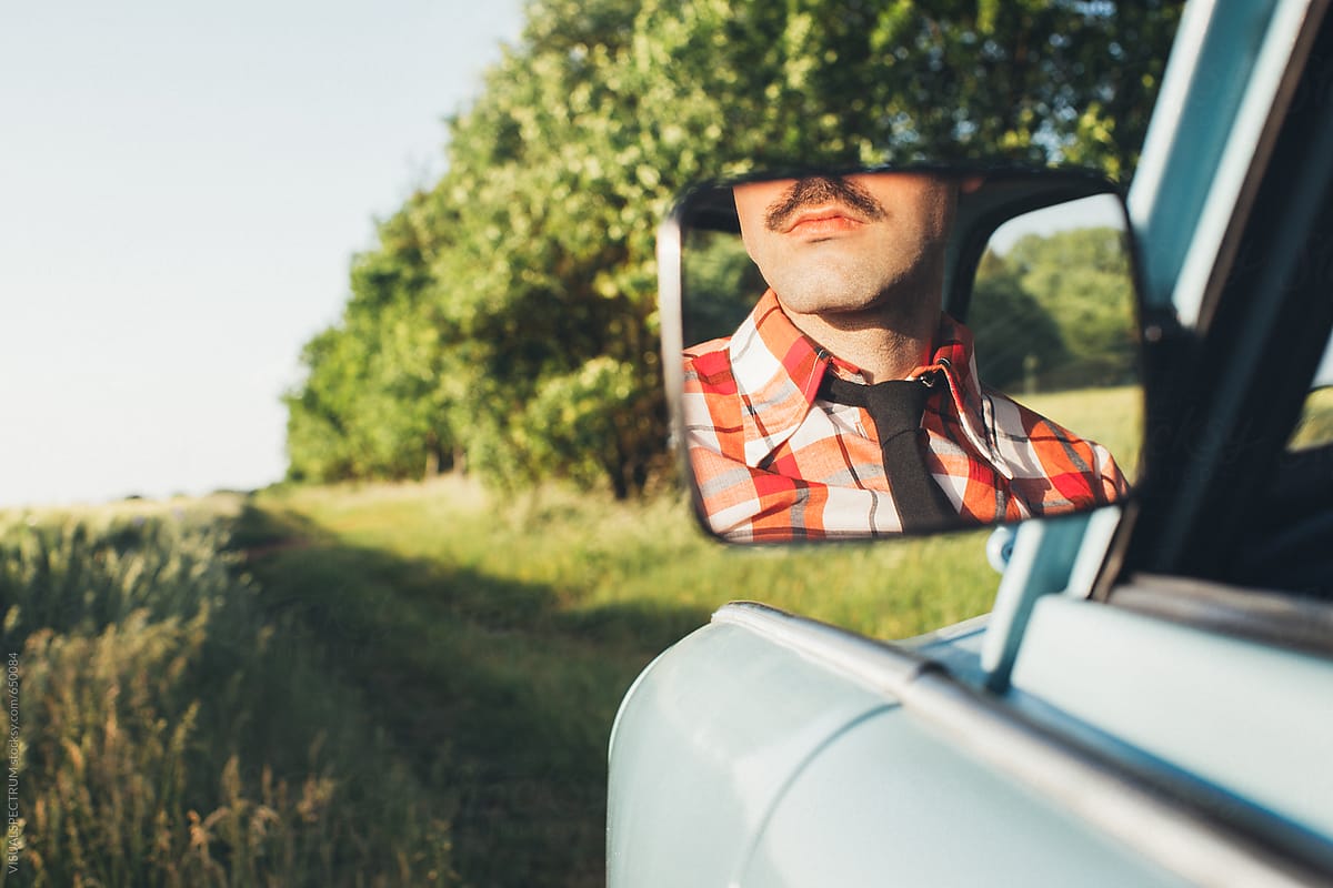 Retro-Styled Young Man With Moustache in Rear Mirror of Vintage Car