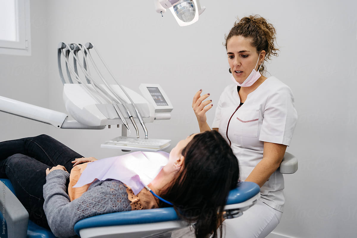 Dentist talking with female patient before intervention