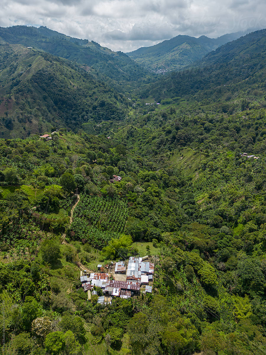 Drone view of green mountains with village and grassy valley