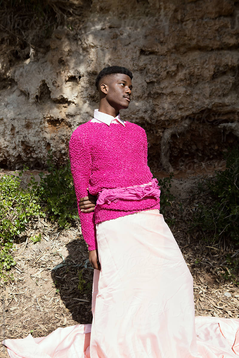 Young confident black man posing in nature on a sunny day wearing pink