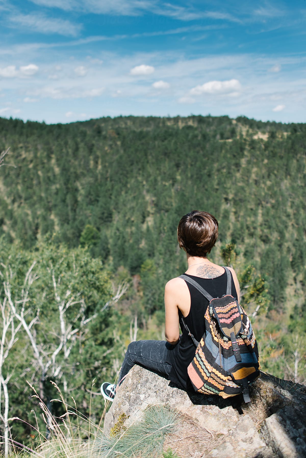 Woman with backpack sitting on a rock
