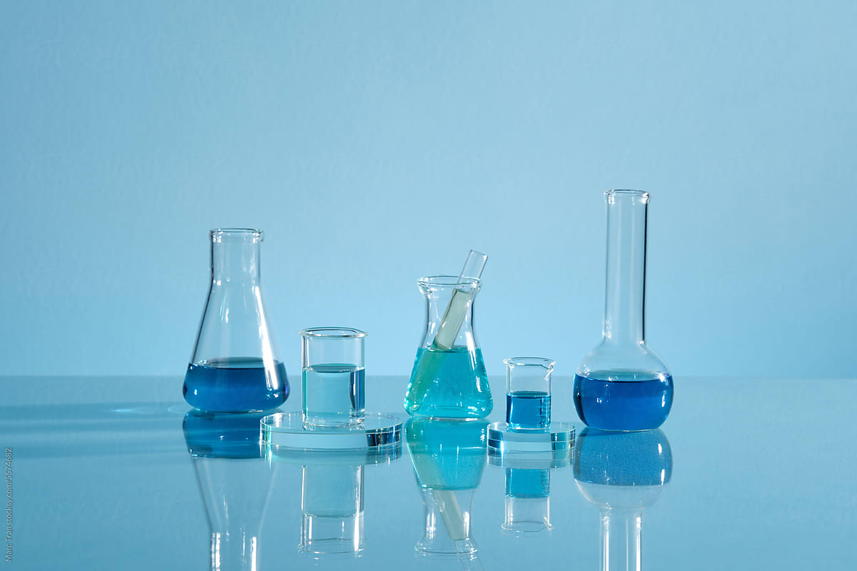 Laboratory glassware with liquid isolated on blue