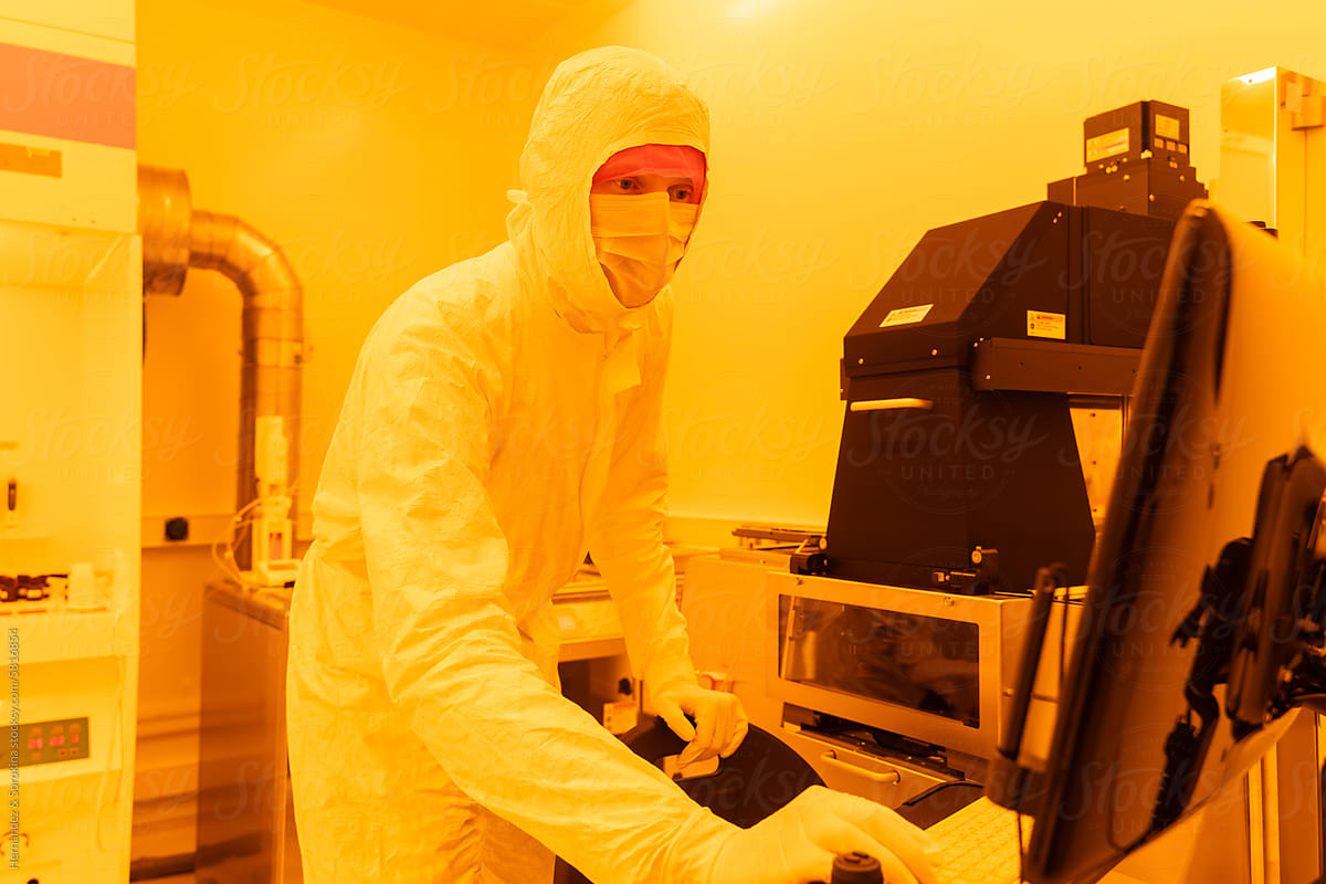 Scientist Using Computer In Yellow Clean Room