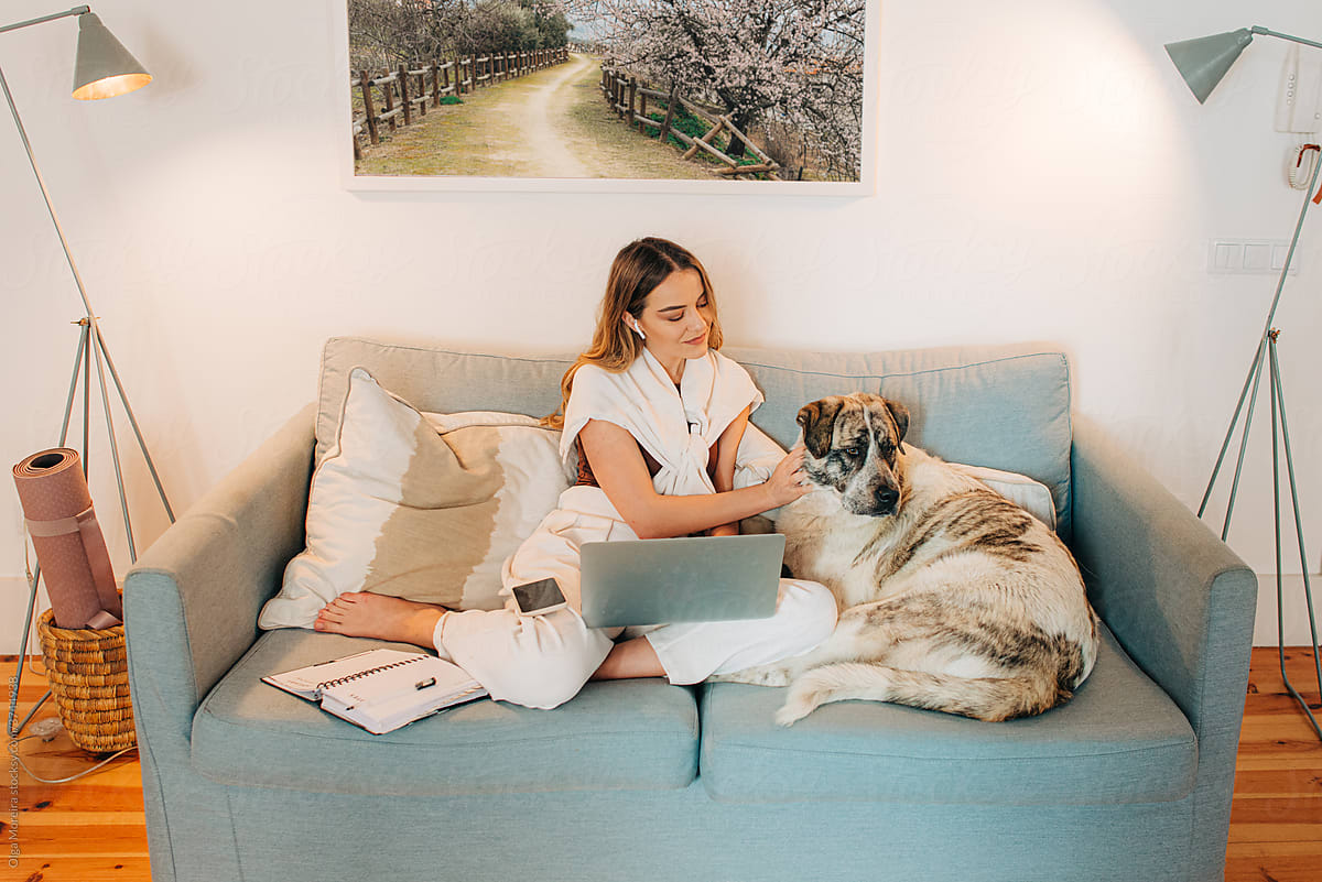 Woman petting her dog while working at home