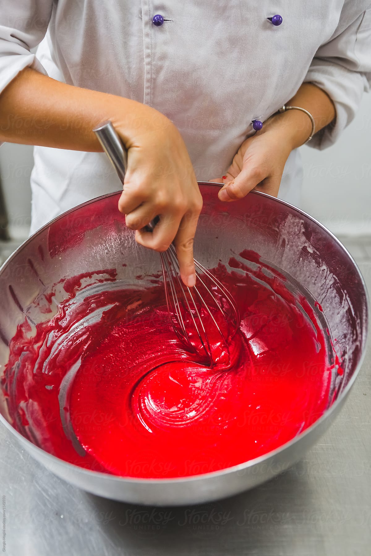 Pastry Chef Stirring Red Batter with a Wire Whisk