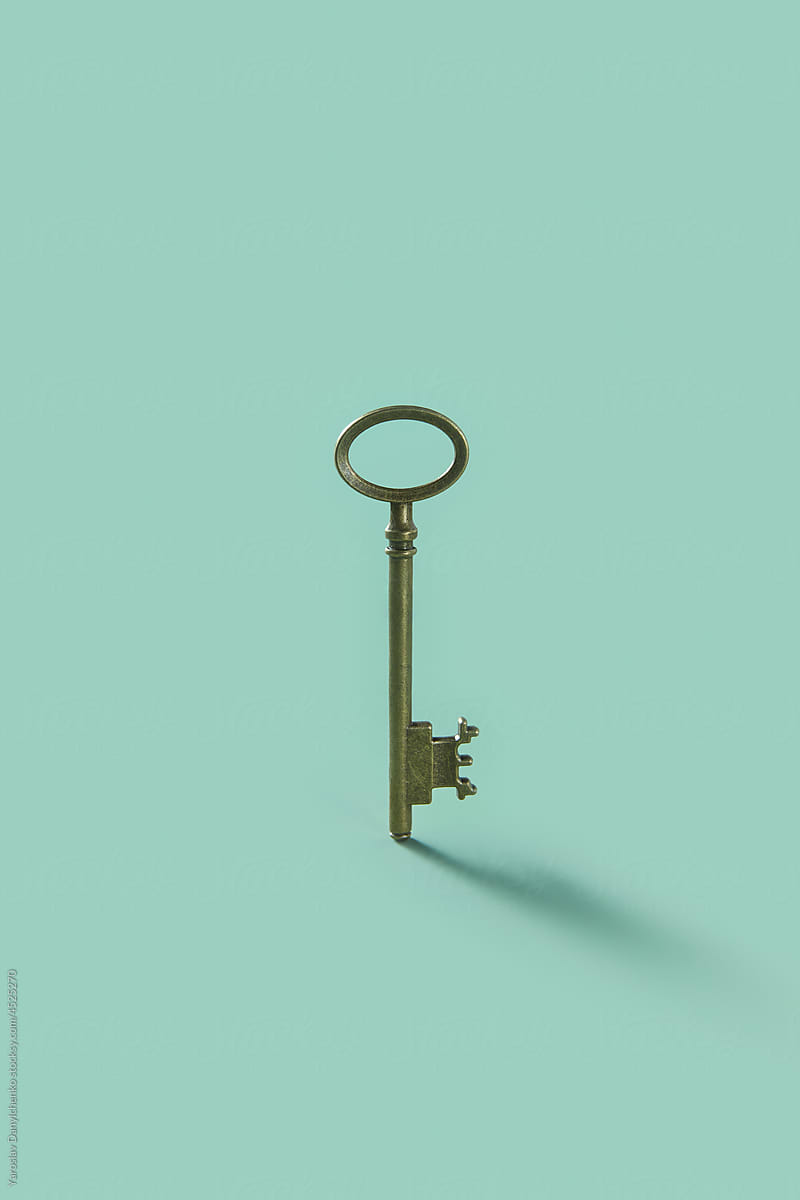 Old vintage key on light blue background