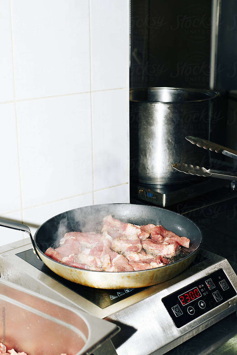 meat is fried in a pan