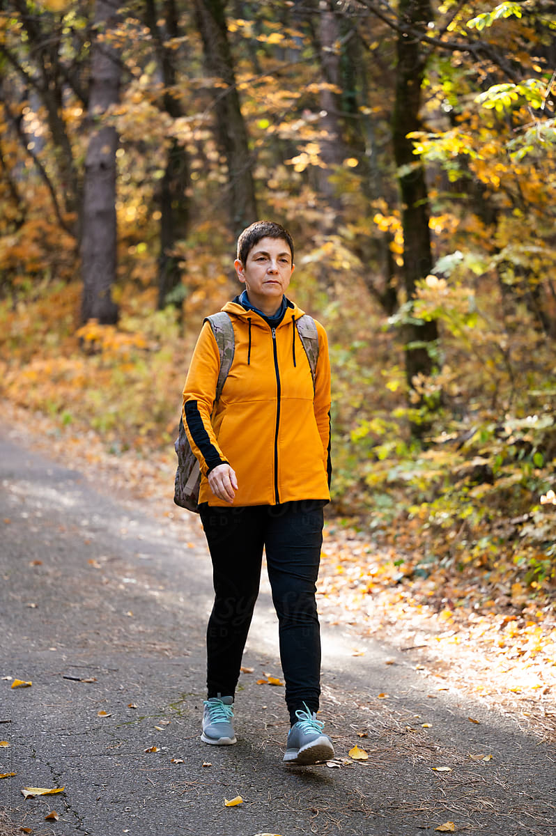 Middle-aged woman walking/hiking in forest