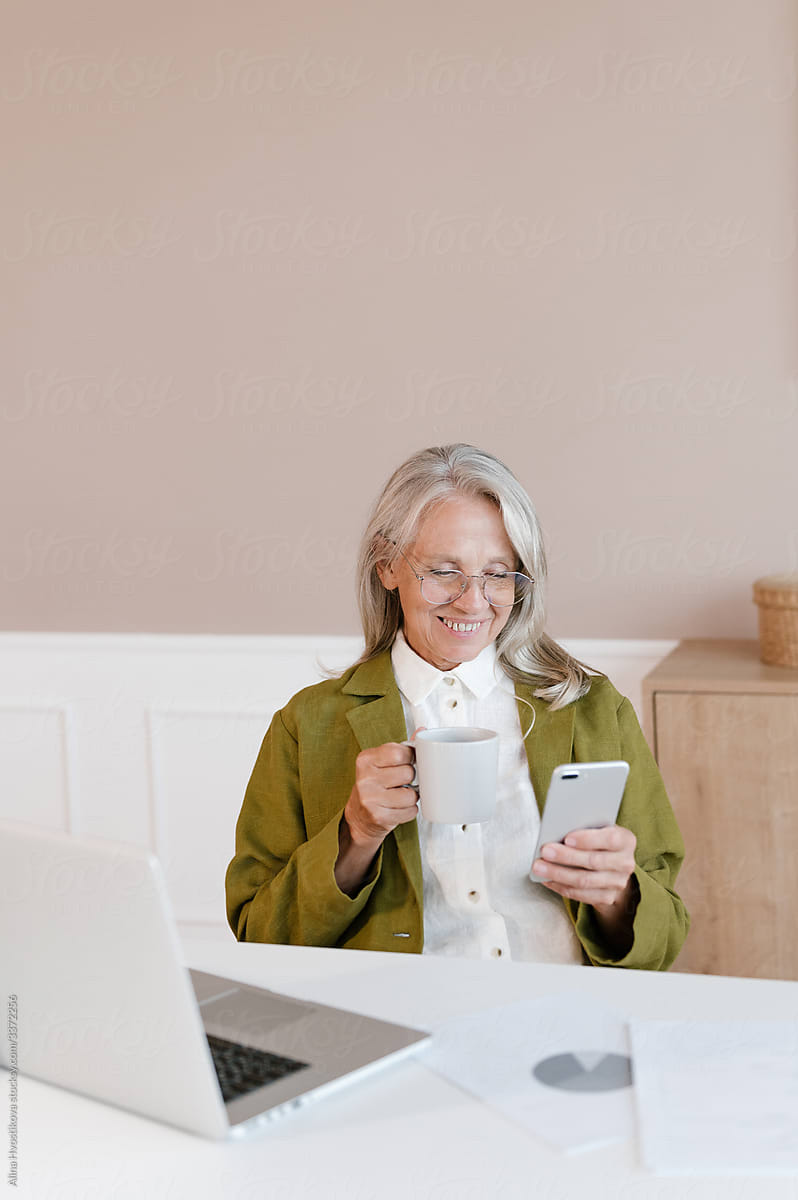 Aged employee browsing smartphone during break