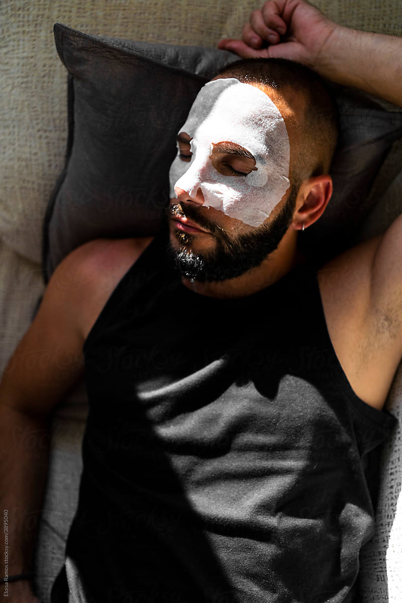 Modern man with a facial mask at home