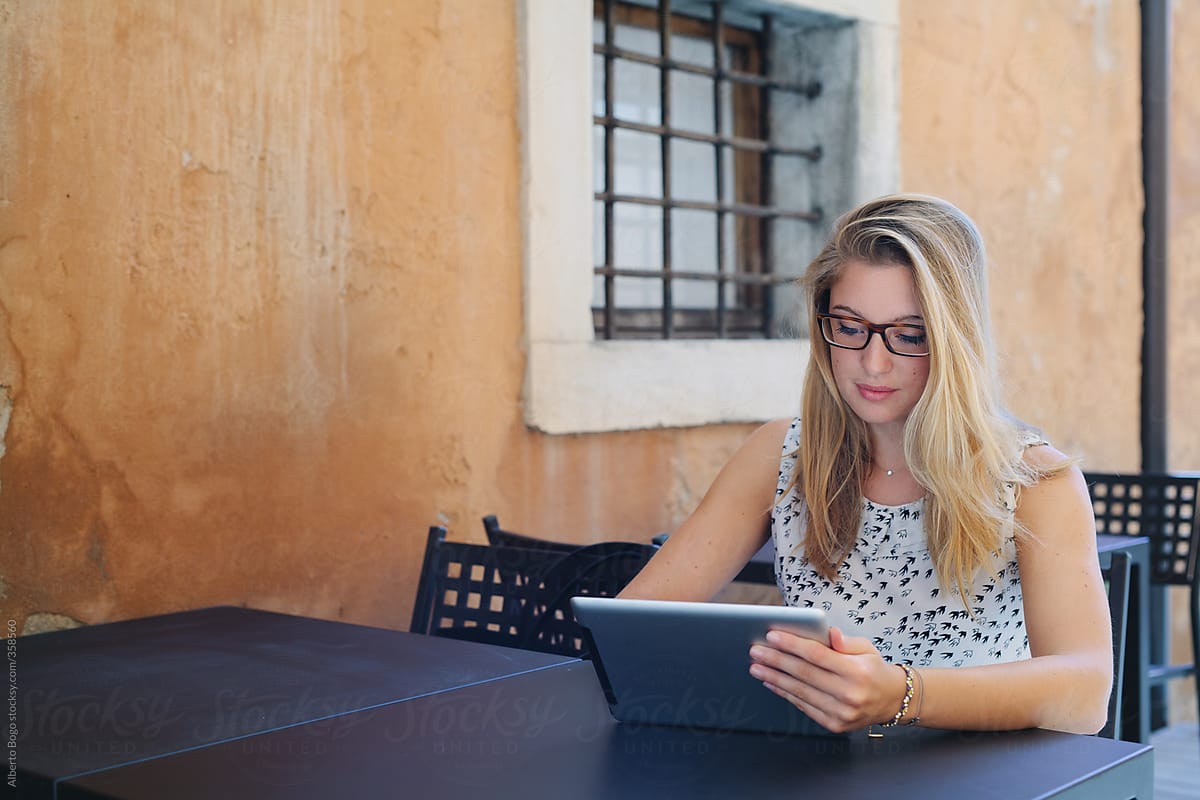 Young business woman using technology sitting at cafe